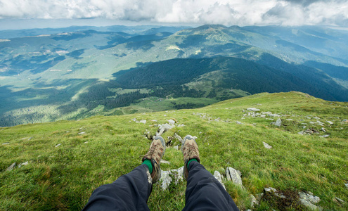 登山靴的旅行者的腿在山图片