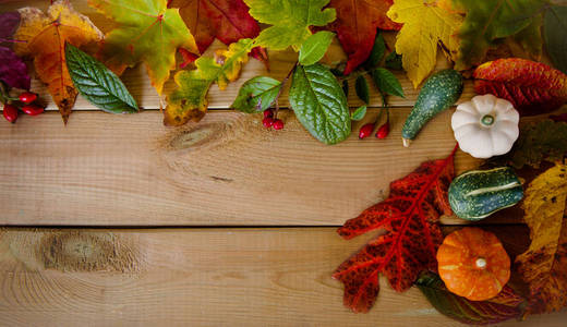 秋天的落叶和南瓜上木制背景