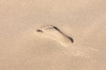一个孩子脚踩在沙滩上的痕迹