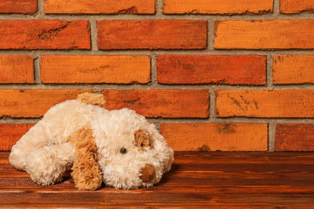 可爱的小狗玩具在旧的红砖墙的背景。新年