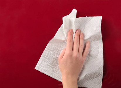 一次性洗脸巾用纸巾擦拭彩色表面的妇女手照片