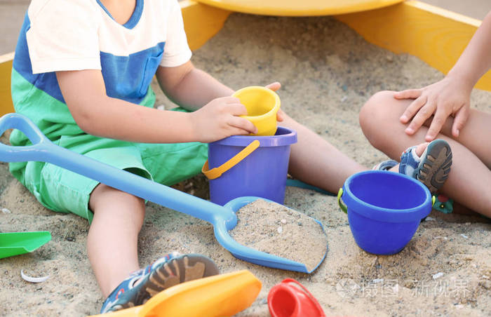 小男孩玩玩具在砂箱户外