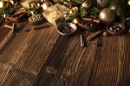 圣诞装饰理念。金色小和圣诞香料都在一个质朴的木制背景与复制空间