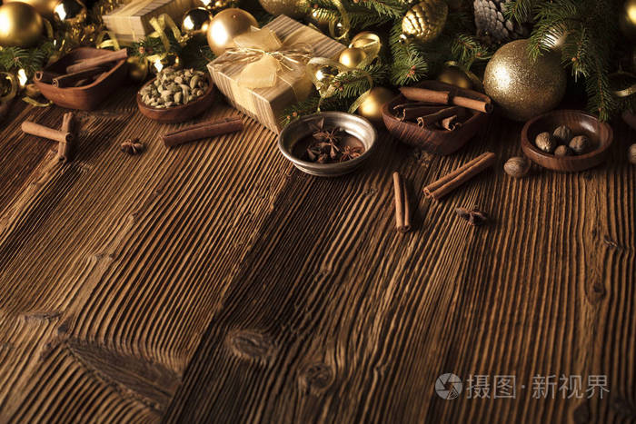 圣诞装饰理念。金色小和圣诞香料都在一个质朴的木制背景与复制空间