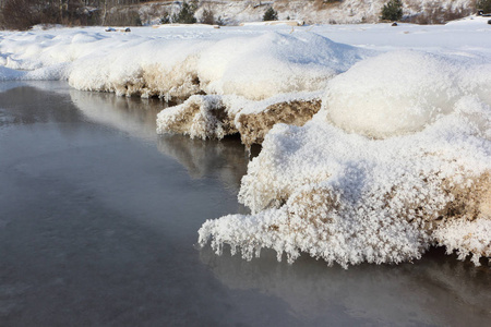在秋天结冰的河上的沙质河岸上的冰柱, Ob