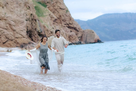 快乐的年轻夫妇在海边玩得开心