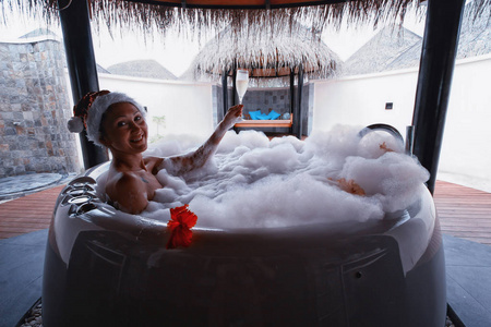 异国情调的圣诞: 性感的美女女孩在浴缸里泡泡澡照片