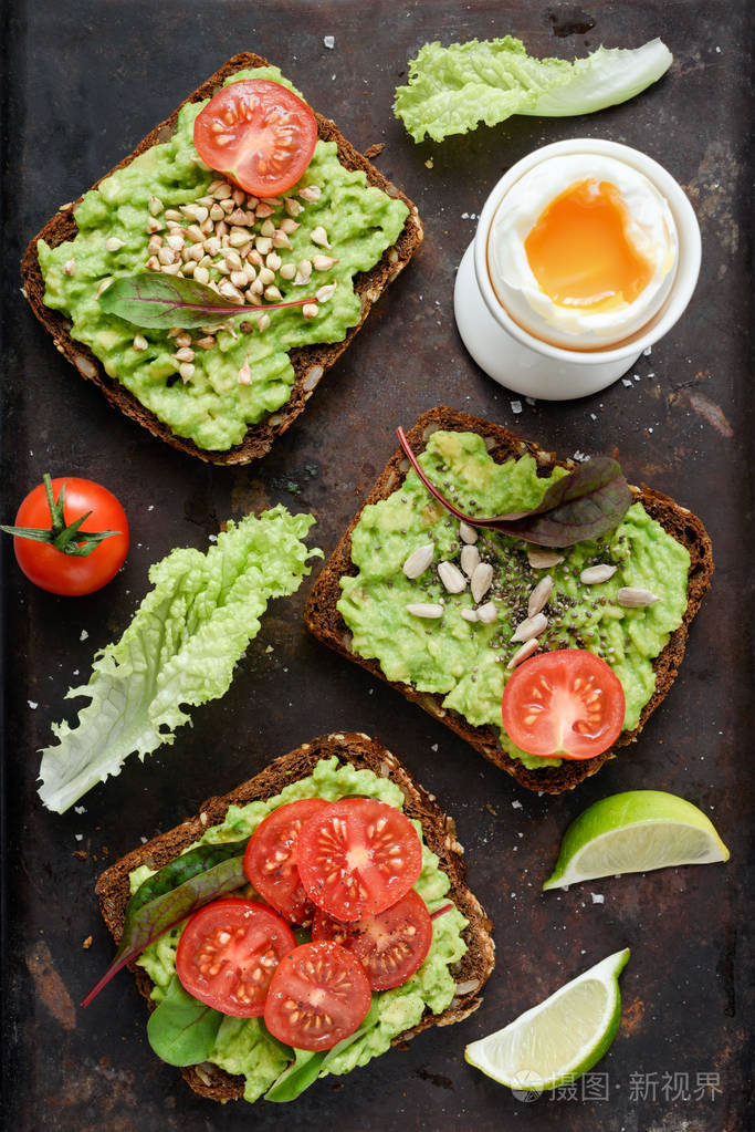 健康的绿色蔬菜面包, 配鳄梨,西红柿,豆芽和种子, 在生锈的背景下煮熟