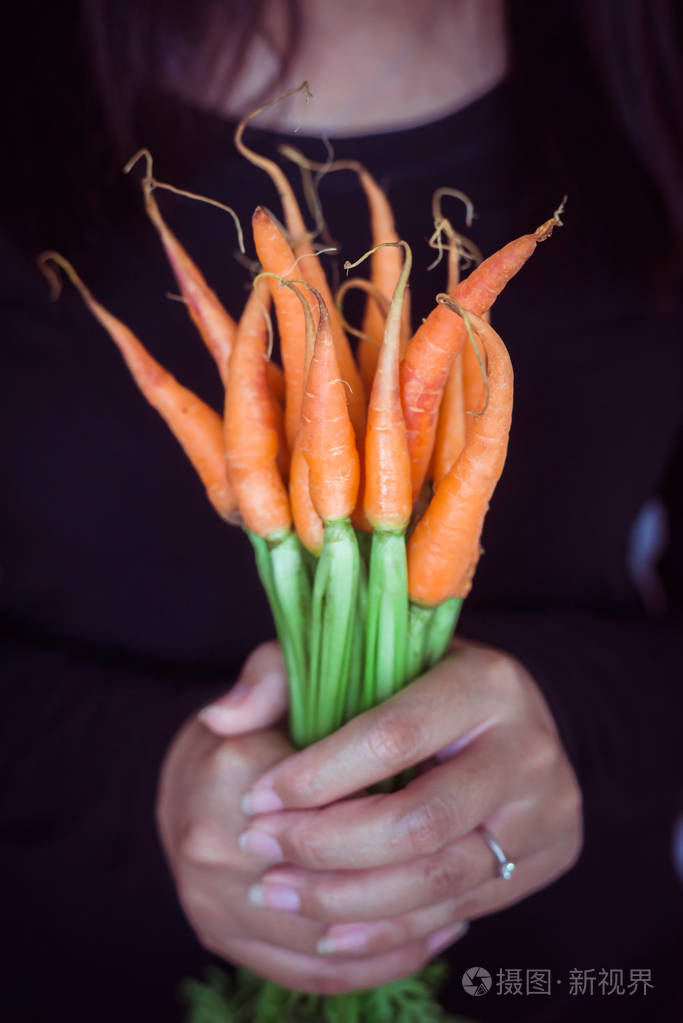 手捧婴儿胡萝卜有机新鲜蔬菜色调的形象
