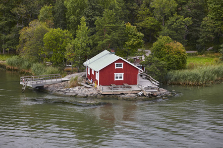 传统的芬兰红色小木屋里。湖岸。芬兰
