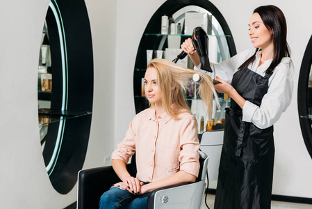 沙龙头发美发师在沙龙烘干顾客头发照片