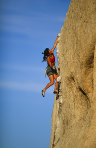紧紧抓住悬崖的女性登山者。