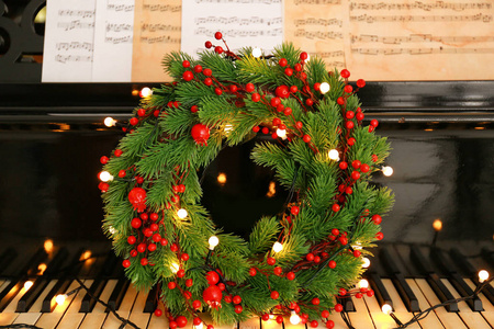 钢琴键盘与圣诞花圈和灯