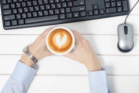 女性手键盘鼠标从电脑杯咖啡