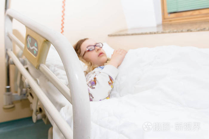 学龄前儿童躺在病房的病床上生病