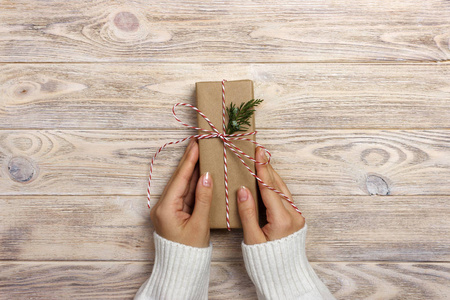 妇女将绑定经典弓的礼物.女人装饰圣诞礼品盒手照片