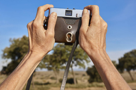 妇女手拿着电影老式照相机在乡下
