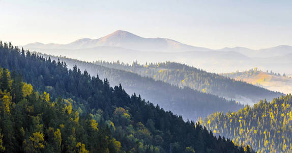 在山的惊人软日出全景。Cerpathian 的山峰和秋天的松树顶丘陵