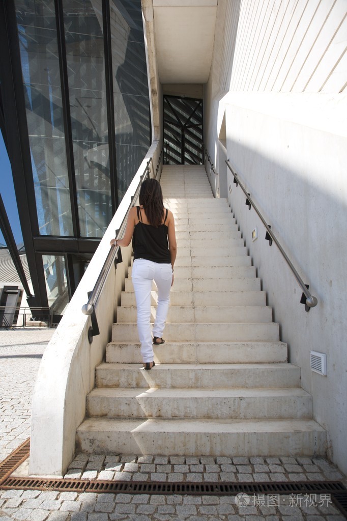楼梯上穿白色牛仔裤的女人