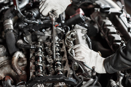 现代柴油发动机工人手和工具的修理。汽车机械工的特写