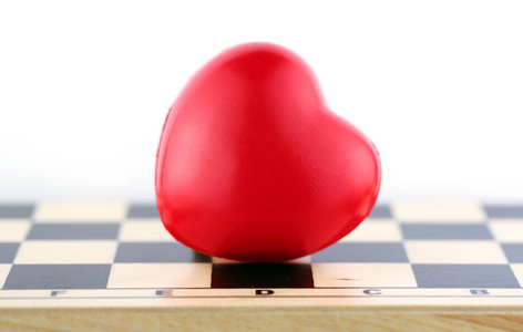 红色心脏在棋书桌以白色背景