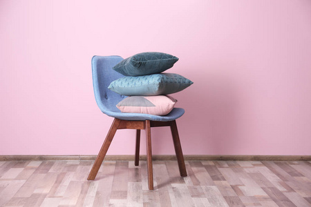 椅子上的枕头叠在颜色墙壁附近