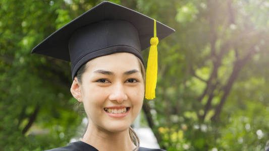 女学生的微笑和快乐毕业袍和帽的感觉