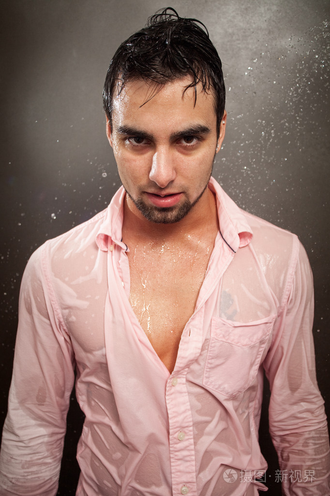 年轻人在浸泡湿粉红色按钮按下的衬衫照片-正版商用图片036dqb-摄图新