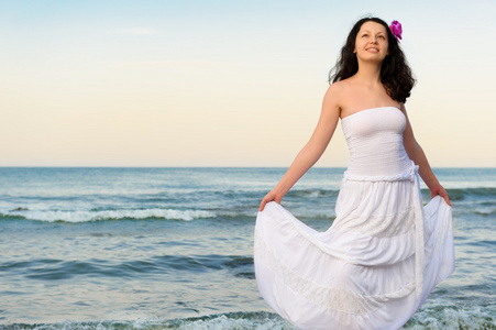 在白色夏装在海岸上的女人图片