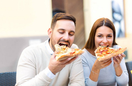 快乐爱情情侣在街头咖啡馆吃披萨