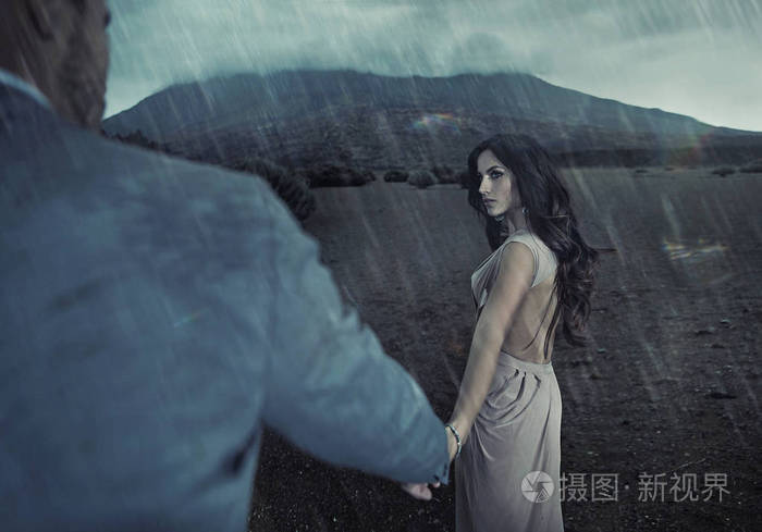 一对情侣在雨中漫步的画像