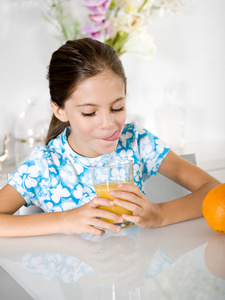 小女孩舌头看着橙汁