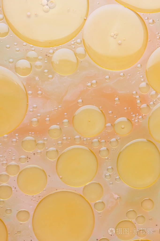 植物油滴在液体抽象背景流行艺术质地淡黄色圆圈背景简约主义粉彩图案