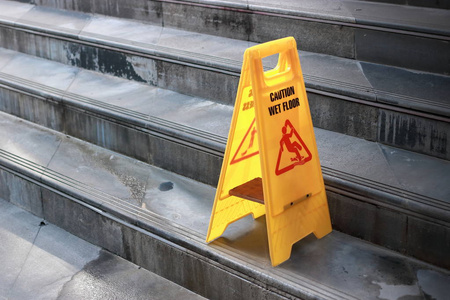 黄色警示室外城市楼梯上的湿地板标志