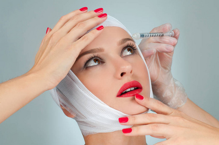 漂亮女人整容后用绷带包扎脸部.美容,时尚和整形外科概念照片