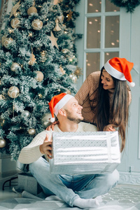 英俊的女人给她的 boyriend 在家里庆祝新年的礼物的人