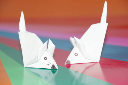 在彩色背景上分离的折纸鼠标。一只老鼠的纸图。日本艺术