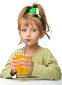 可爱的小女孩在喝橙汁