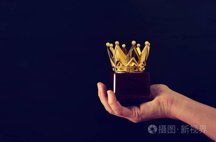 男子手捧皇冠奖奖杯为显示胜利或赢得第一名.闪光叠加