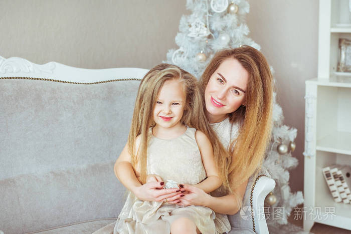 年轻的母亲和她的小女儿在圣诞节的肖像