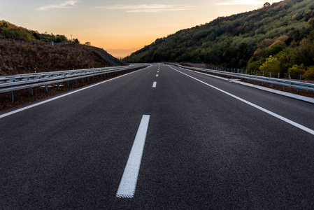 日落时有标记的空公路