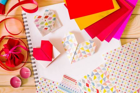 情人节的概念。彩色手工纸心工艺品与折纸纸的木制背景
