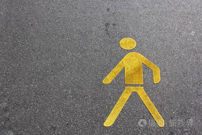在沥青地面上的黄色行人车道标志