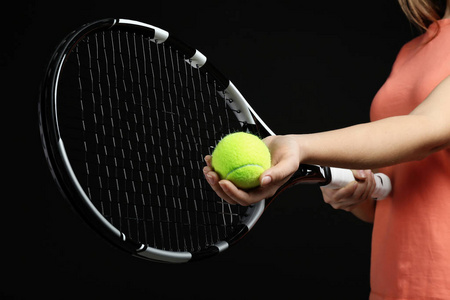 妇女与网球球拍和球在黑背景