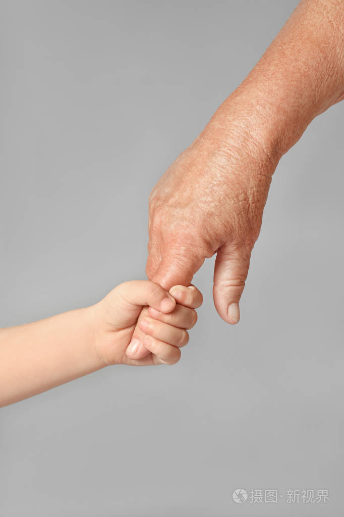 浅灰色背景下的老人与婴儿手