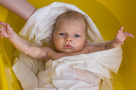 新生儿抱着妈妈沐浴在黄色的浴缸里, 新生的玫瑰手