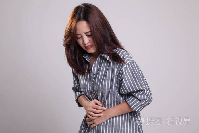 年轻的亚裔女子胃疼