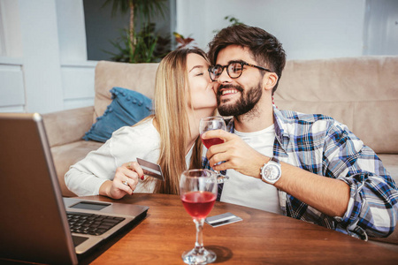 技术, 网上购物和人的概念微笑快乐夫妇与笔记本电脑和信用卡在家里