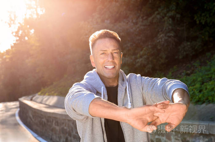 成熟运动的男人在户外跑步前变暖