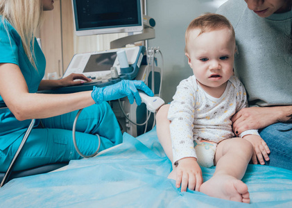 医生和婴儿女孩与母亲在超声诊断。医疗设备。超声